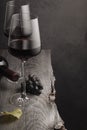 Two glasses of red wine, a bottle and grapes on an old wooden table Royalty Free Stock Photo