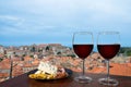 Two glasses of red wine with charcuterie assortment on view of Dubrovnik red roofs. Glass of red wine with different snacks - Royalty Free Stock Photo