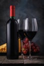 Two glasses of red wine with cheese and grapes on a wooden table Royalty Free Stock Photo