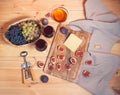 Two glasses of red wine, corkscrew, bunches of grape in wicker basket, figs, cheese and  honey in glass bowl on wooden table Royalty Free Stock Photo