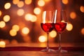 Two glasses of red wine on festive golden bokeh background. Saint Valentines day concept