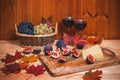 Glasses of red wine, fig, cheese, bunchs of grape, honey and colorful autumn maple leaves on wooden table. Selective focus Royalty Free Stock Photo