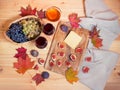 Two glasses of red wine, figs, piece of cheese, bunches of grape, honey and autumn maple leaves on wooden table Royalty Free Stock Photo