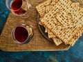 Two glasses of red wine and matzah - traditional Jewish bread. Simple brown mat and dark blue background. Feast of the Jewish Royalty Free Stock Photo