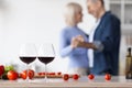 Two glasses of red wine over dancing senior couple Royalty Free Stock Photo