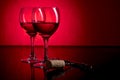 Two glasses of red wine on red and black background Royalty Free Stock Photo