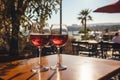 Two glasses of red wine in a restaurant overlooking beautiful mediterranean landscape on sunset. Drinking wine, evening lights,