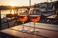 Two glasses of red wine in a restaurant overlooking beautiful mediterranean landscape on sunset. Drinking wine, evening lights,