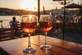 Two glasses of red wine in a restaurant overlooking beautiful mediterranean landscape on sunset. Drinking wine, evening lights,