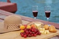 Two glasses of red wine, served outdoor with fruits and beautiful blue ocean view. Royalty Free Stock Photo