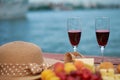 Two glasses of red wine, served outdoor with fruits and beautiful blue ocean view. Royalty Free Stock Photo