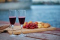 Two glasses of red wine, served outdoor with fruits and beautiful blue ocean view. Royalty Free Stock Photo