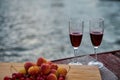 Two glasses of red wine, served outdoor with fruits and beautiful blue ocean view. Royalty Free Stock Photo