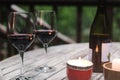 Two glasses with red wine standing on the wooden table with burning candle