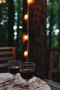 Two glasses of red wine standing on the wooden table on the outdoor patio. Royalty Free Stock Photo