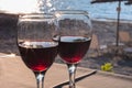 Two glasses of red wine with sun reflection, sea, summer vacation background Royalty Free Stock Photo