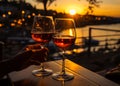 Two glasses of red wine are on the table in the restaurant on the background of the sea and the sunset Royalty Free Stock Photo