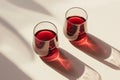 Two glasses of red wine on white tabletop. Direct sunlight from the window with strong shadows. Top view, copy space Royalty Free Stock Photo