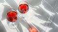 Two glasses of red wine on white tabletop. Direct sunlight from the window with strong shadows. Top view, copy space Royalty Free Stock Photo