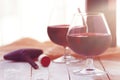 Two glasses of red wine on a white wooden table, sunset light. Royalty Free Stock Photo