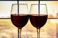 Two glasses of red wine on the windowsill and rainy window background, autumn home time Royalty Free Stock Photo