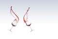 Two glasses of red wine with the wine splashing out of a glass, isolated over white background Royalty Free Stock Photo