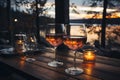 Two glasses of red wine on wooden table of outdoor restaurant on a background of scandinavian landscape. Drinking wine in outdoor Royalty Free Stock Photo