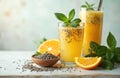 Two glasses of refreshing basil seed orange drink. Nutritious beverages with fresh fruit, herbs on light background. Bowl of Royalty Free Stock Photo