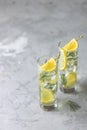 Two glasses of refreshing lemon lime drink with ice cubes in glass goblets with water drops against a light gray background. Royalty Free Stock Photo