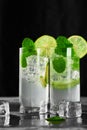 Two glasses of refreshing mojito cocktail with ice cubes. Copy space. Low angle studio shot. Vertical frame Royalty Free Stock Photo