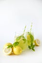 Two glasses of refreshing non alcoholic mojito drink with lemon slices, mint leaves and ice. Studio shot of iced lemonade isolated Royalty Free Stock Photo