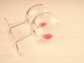 Two glasses with the remains of wine lie on a white wooden background, a copy of the space Royalty Free Stock Photo