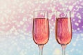 Two glasses of rose champagne with a light snow bokeh as a background. Romantic dinner. Winter, Christmas or New Year holiday Royalty Free Stock Photo