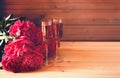 Two glasses of rose champagne and red peony flowers on wooden table. Selective focus Royalty Free Stock Photo