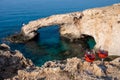 Two glasses of rose dry white wine served on rocks in blue sea bay with Love Bridge on background near Ayia Napa touristic town on Royalty Free Stock Photo