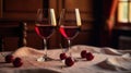 Two glasses of ruby red wine rest on a linen tablecloth, accompanied by scattered ripe cherries, bathed in warm, ambient light. Royalty Free Stock Photo