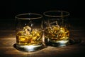 Two glasses of scotch whiskey or cognac and ice cubes on dark wooden background Royalty Free Stock Photo