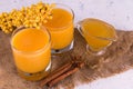 Two glasses with sea buckthorn, honey and cinnamon fruit drink.