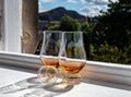 Two glasses of single malt scotch whisky served on old window sill in Scottisch house with view on old part of Edinburgh, Scotland Royalty Free Stock Photo