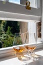 Two glasses of single malt scotch whisky served on old window sill in Scottisch house with view on old part of Edinburgh, Scotland Royalty Free Stock Photo