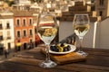 Two glasses of Spanish dry rueda white wine served with olives on roof terrace with view on old part of Andalusian town Granada, Royalty Free Stock Photo