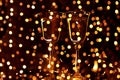 Two glasses with sparkling wine champagne on a black background and glittering golden bokeh. Royalty Free Stock Photo