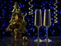 Two glasses of sparkling wine and a Christmas tree on a blue bokeh background. Royalty Free Stock Photo