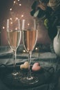 Two glasses with sparkling wine and heart shaped macarons, dimmed light Royalty Free Stock Photo