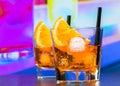 Two glasses of spritz aperitif aperol cocktail with orange slices and ice cubes on bar table, disco atmosphere background Royalty Free Stock Photo