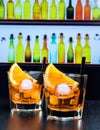 Two glasses of spritz aperitif aperol cocktail with orange slices and ice cubes on bar table, disco atmosphere background Royalty Free Stock Photo