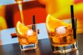 Two glasses of spritz aperitif aperol cocktail with orange slices and ice cubes on bar table, disco atmosphere background Royalty Free Stock Photo