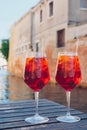 Two glasses of Spritz Veneziano cocktail served near the Venetian canal.