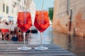 Two glasses of Spritz Veneziano cocktail served near the Venetian canal