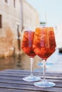 Two glasses of Spritz Veneziano cocktail served near the Venetian canal